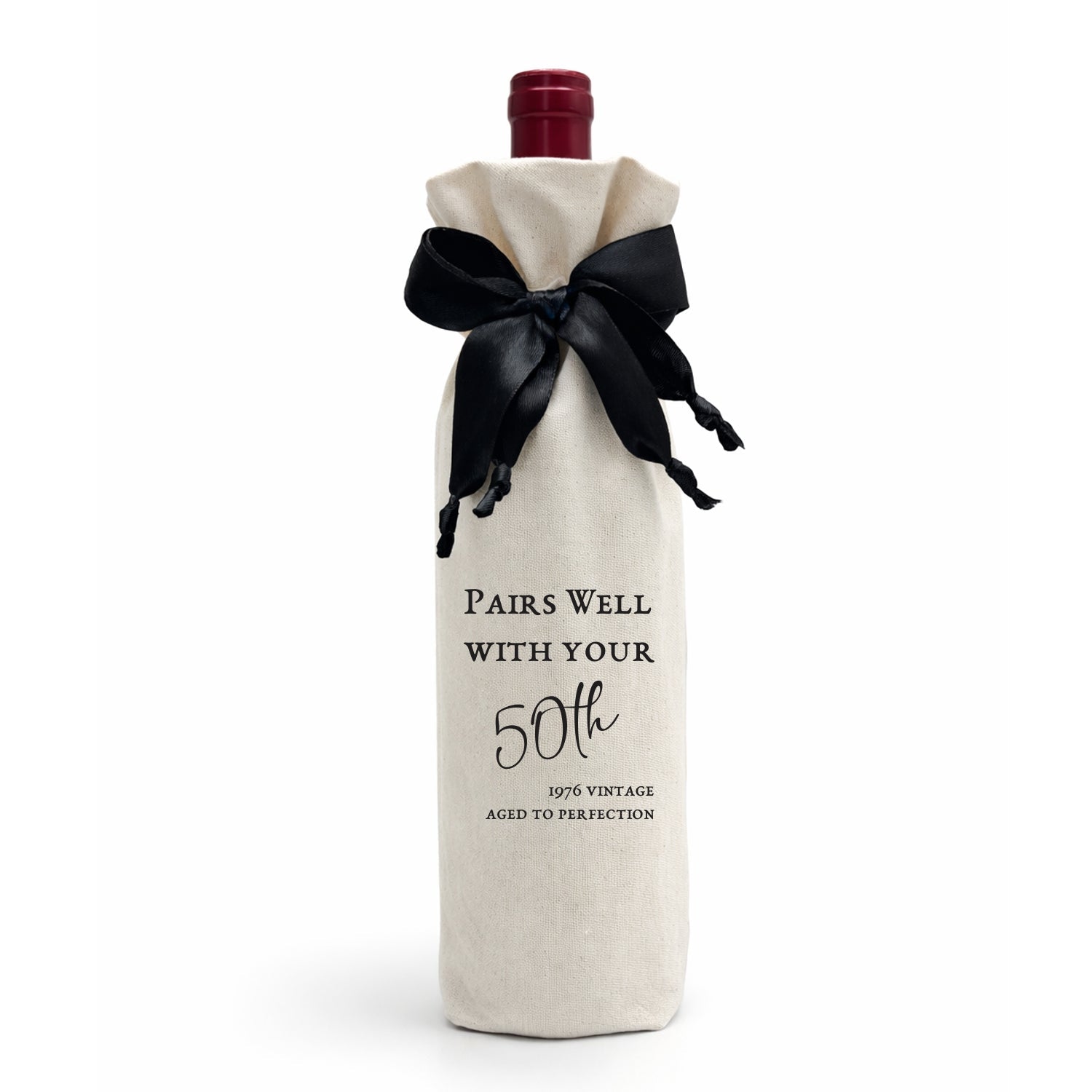 A luxury gift bag, made from calico cotton tied with a black satin bow. The bag reads: "Pairs Well with Your 50th — 1976 Vintage — Aged to Perfection." Made in SA.