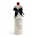 Wine bottle wrapped in a calico cotton gift bag, luxe satin ribbon with black text on a white background, Pairs Well With Your New Home.